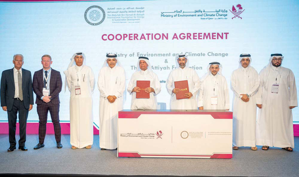 Minister of Environment and Climate Change H E Sheikh Dr. Faleh bin Nasser bin Ahmed bin Ali Al Thani and  Chairman of Al Attiyah Foundation and former Minister of Energy and Industry of Qatar, H E Abdullah bin Hamad Al Attiyah showing documents after signing the agreement. President of Qatar University Dr. Omar Al Ansari and other officials are also seen. 