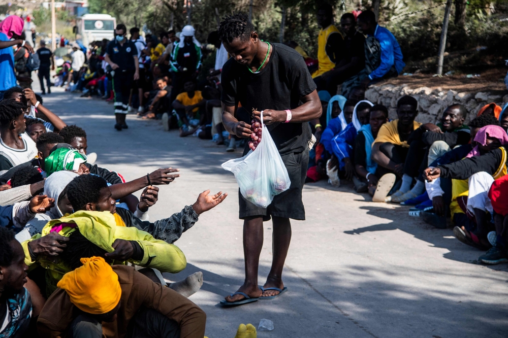 Migrants gather outside the operational centre called 