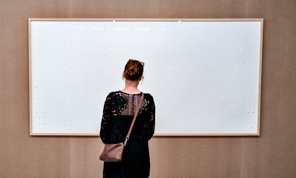 A woman stands in front of an empty frame hung up at the Kunsten Museum in Aalborg, Denmark, on September 28, 2021. (Photo by Henning Bagger / Ritzau Scanpix / AFP)