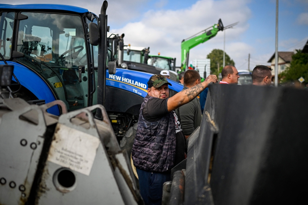 A farmer stands in front of a tractor during a protest against the lifting of ban on imports of grain coming from Ukraine, in Dragoman, near the border with Serbia, on September 18, 2023. (Photo by Nikolay DOYCHINOV / AFP)
