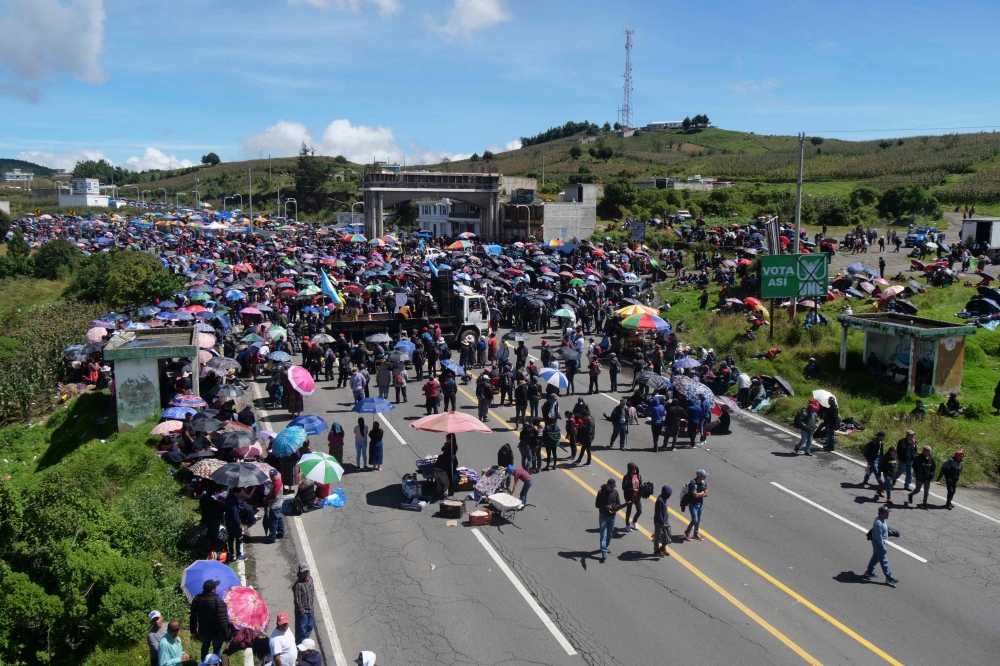 Indigenous people block a road during a protest demanding the resignation of Attorney General Consuelo Porras and prosecutor Rafael Curruchiche in San Cristobal Totonicapan, Guatemala, on October 2, 2023. (Photo by Gustavo RODAS / AFP)
