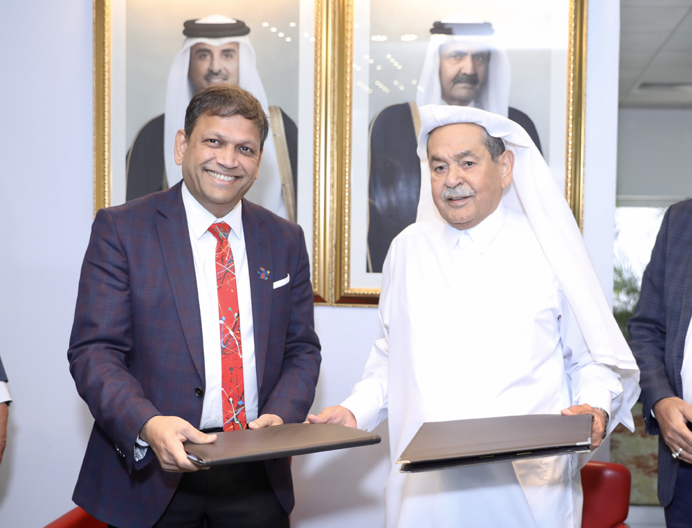 Officials exchange documents during the collaboration to pioneer new digital frontiers in Qatar.
