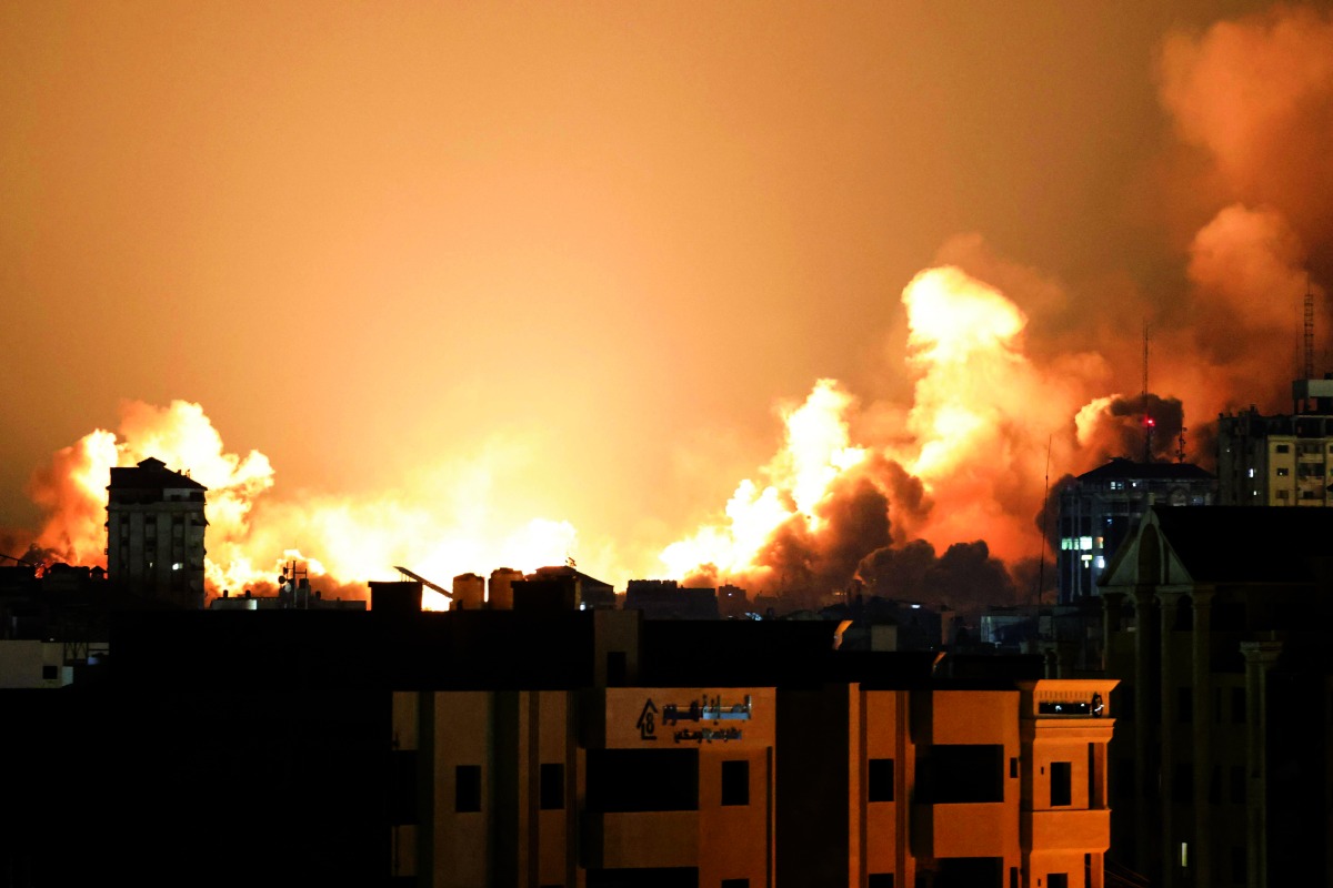 A plume of smoke rises above buildings in Gaza City during an Israeli air strike yesterday.