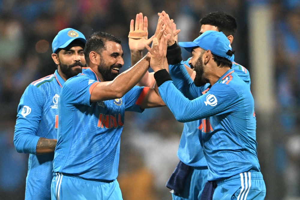 India celebrates during the 2023 ICC Men's Cricket World Cup one-day international (ODI) match between India and Sri Lanka at the Wankhede Stadium in Mumbai on November 2, 2023. (Photo by Punit Paranjpe / AFP)