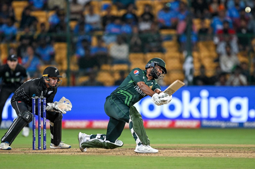 Pakistan's Fakhar Zaman (R) plays a shot during the 2023 ICC Men's Cricket World Cup one-day international (ODI) match between New Zealand and Pakistan at the M. Chinnaswamy Stadium in Bengaluru on November 4, 2023. (Photo by Sajjad HUSSAIN / AFP)