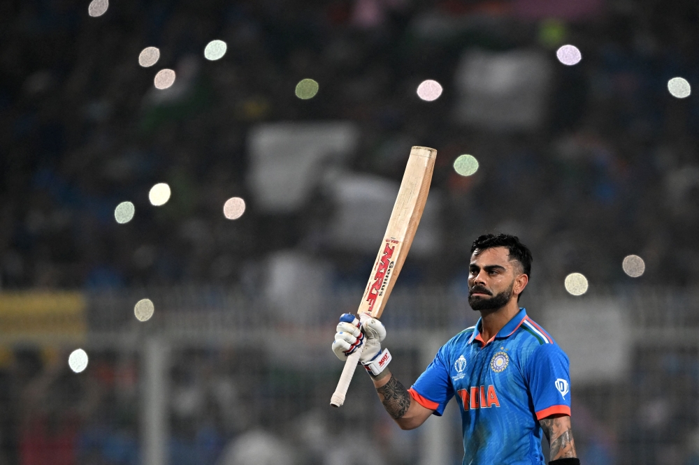 India's Virat Kohli celebrates after scoring a century (100 runs) during the 2023 ICC Men's Cricket World Cup one-day international (ODI) match between India and South Africa at the Eden Gardens in Kolkata on November 5, 2023. (Photo by DIBYANGSHU SARKAR / AFP)