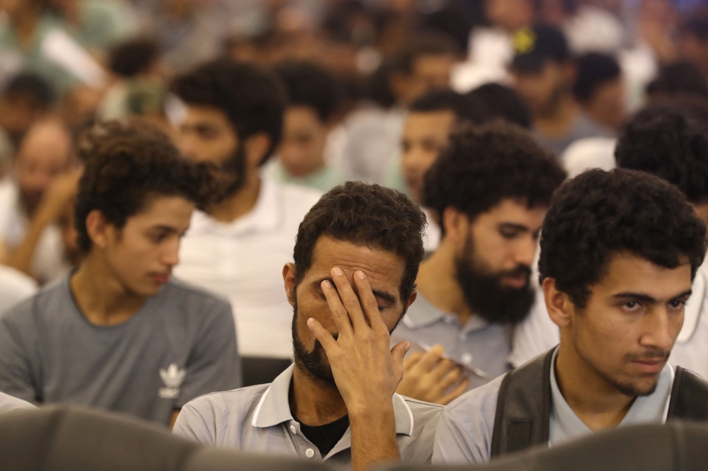 Migrants await processing during a deportation operation by the Ministry of Interior in the Tripoli-based government, in the Libyan capital on November 6, 2023. (Photo by Mahmud Turkia / AFP)
