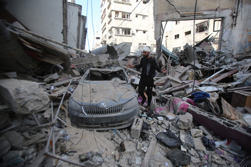 A Palestinian man inspects the damage in Gaza City's Shati refugee camp on November 6, 2023. (Photo by Bashar Taleb / AFP)