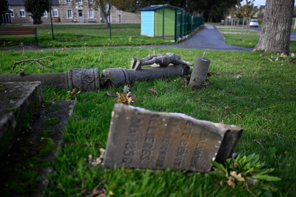 This general view shows a cross of a calvary lying on the ground after it was hit by strong winds due to Storm Ciaran at Saint-Igneuc, western France on November 6, 2023. (Photo by Damien MEYER / AFP)
