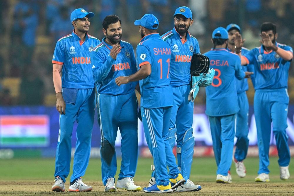India's players celebrate their win at the end of the 2023 ICC Men's Cricket World Cup one-day international (ODI) match against Netherlands at the M. Chinnaswamy Stadium in Bengaluru on November 12, 2023. (Photo by R.Satish Babu / AFP) 