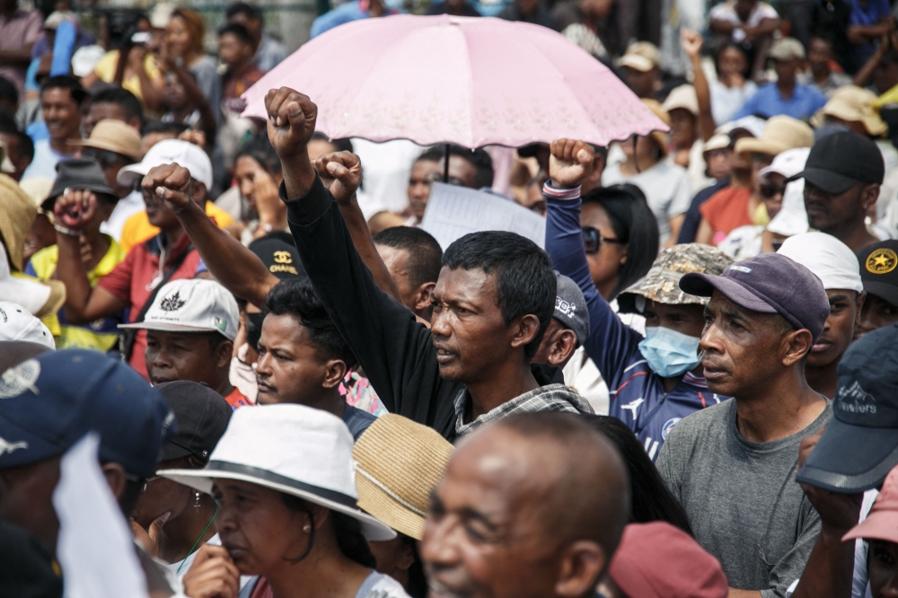 Supporters cheer as members of the collective of opposition candidates march through the streets of Analamahitsy district to protest against the holding of the 2023 Presidential Election, in Antananarivo, on November 14, 2023. (Photo by RIJASOLO / AFP)
