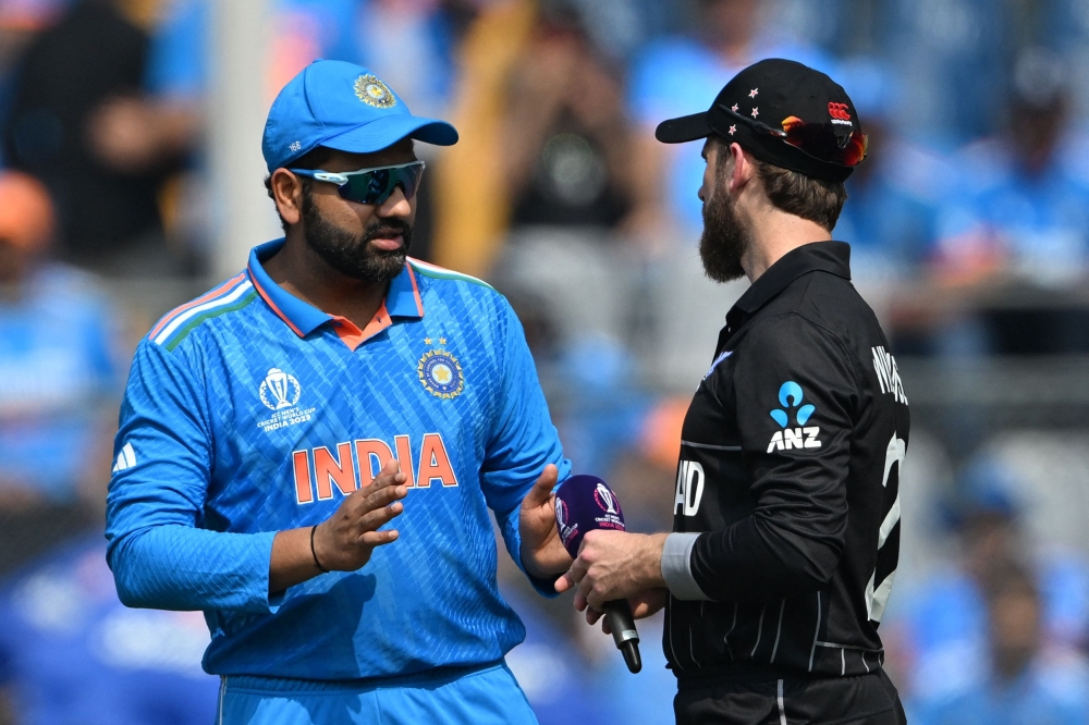 India's captain Rohit Sharma talks with his New Zealand's counterpart Kane Williamson (R) during the toss before the start of the 2023 ICC Men's Cricket World Cup one-day international (ODI) first semi-final match between India and New Zealand in Mumbai on November 15, 2023. (Photo by Punit Paranjpe / AFP)