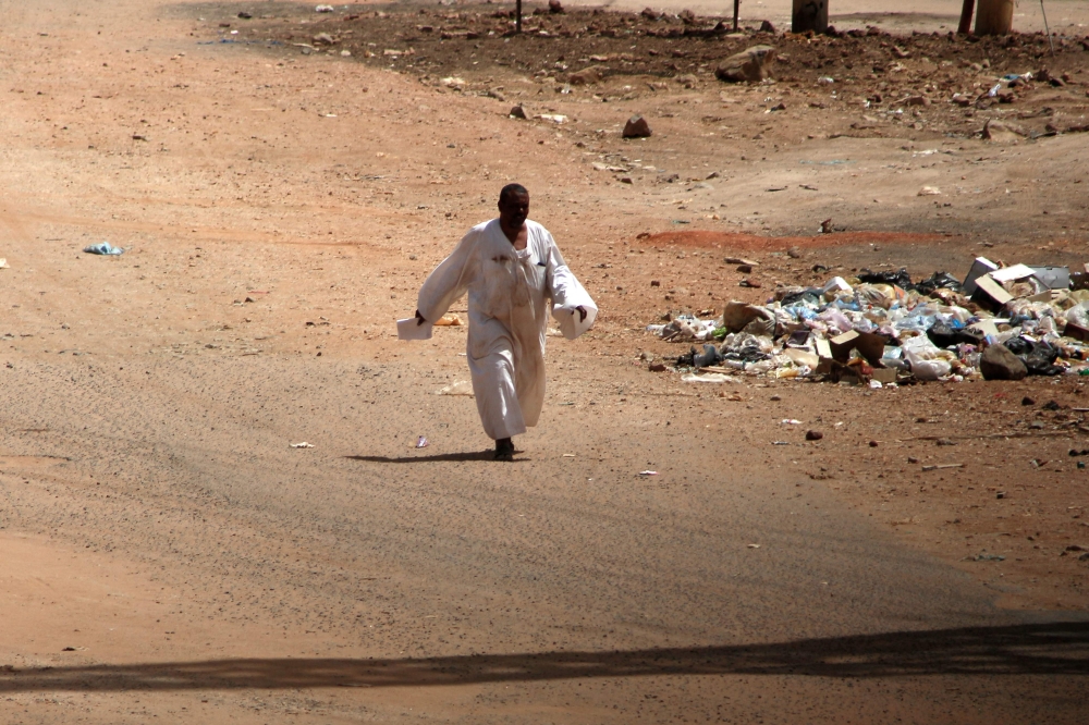 File: A man walks down a road in Khartoum amid ongoing fighting between the forces of two rival generals, on May 18, 2023. (Photo by AFP)