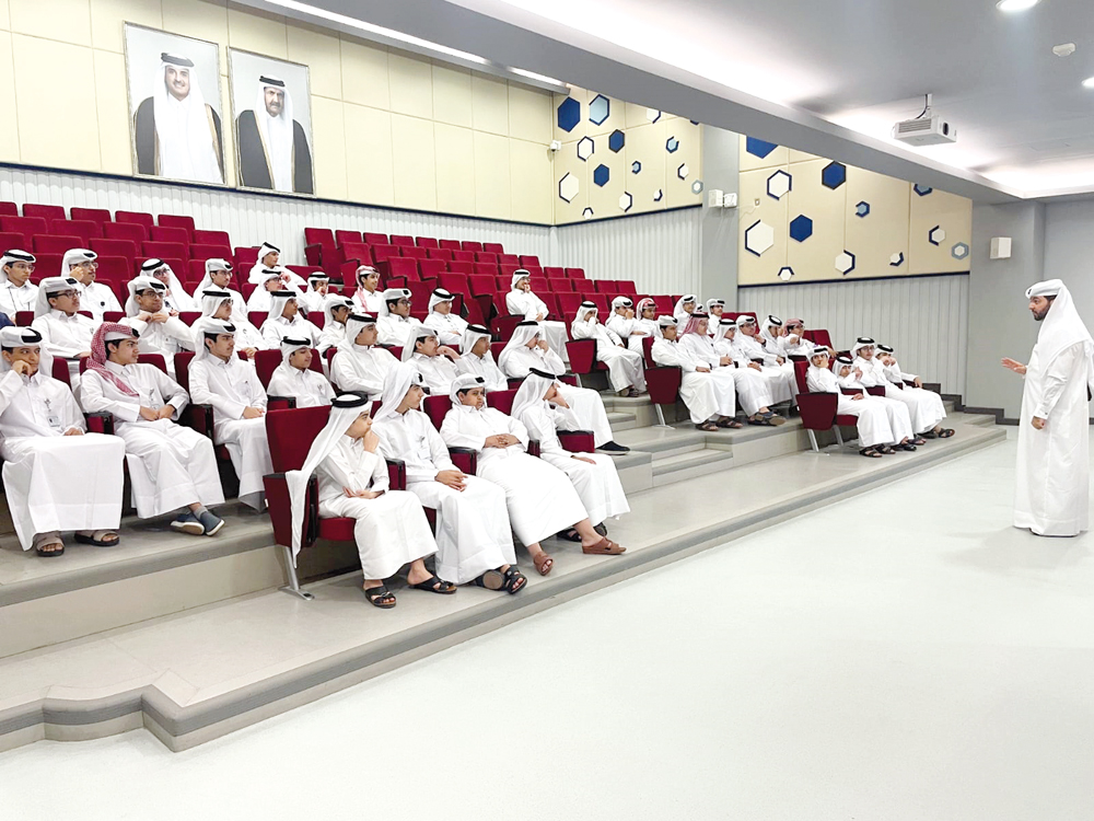 Students listen to an NHRC official at a school. 