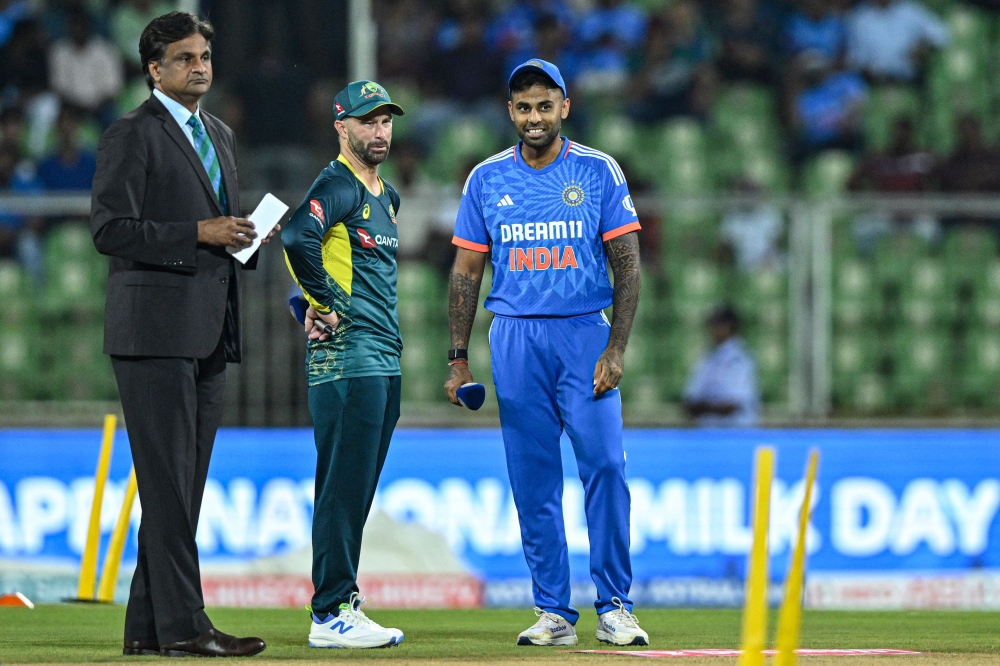 India's captain Suryakumar Yadav (R) and as his Australia's counterpart Matthew Wade (C) looks on during the toss before the start of the second Twenty20 international cricket match between India and Australia at the Greenfield International Stadium in Thiruvananthapuram on November 26, 2023. (Photo by R.Satish BABU / AFP).