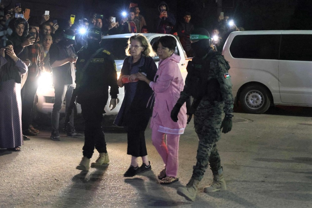 Filipina Noralyn Babadilla (second right) before she was handed over to the Red Cross in Rafah, in the southern Gaza Strip, on November 28, 2023. (Photo by Said Khatib / AFP)

