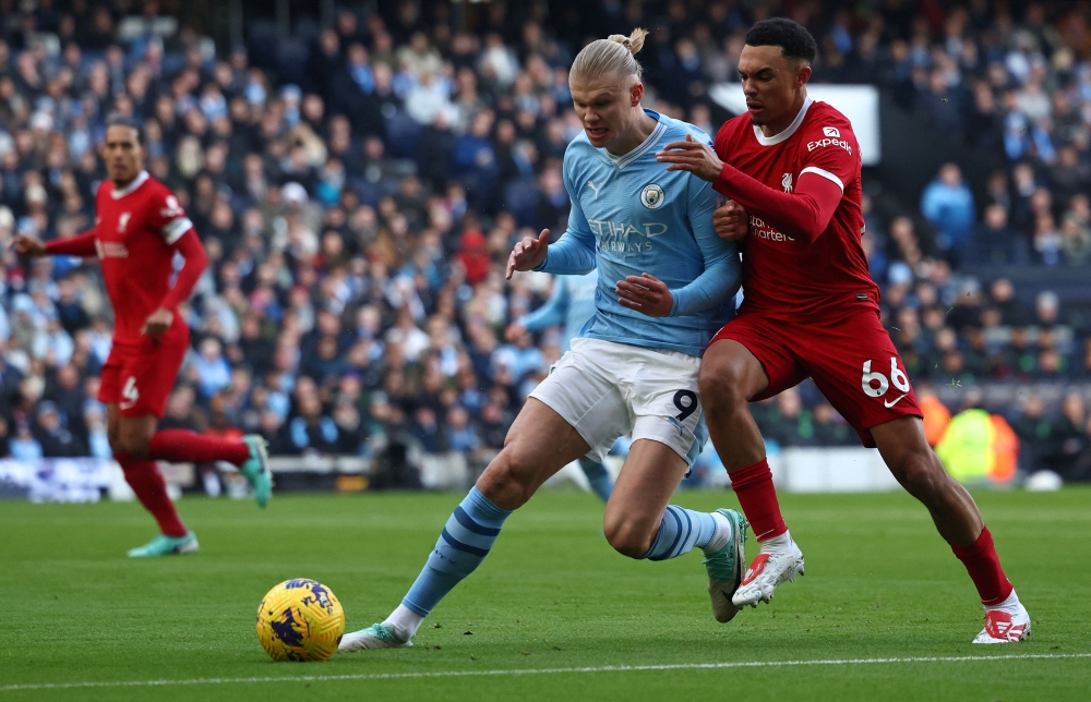 Liverpool's English defender #66 Trent Alexander-Arnold (R) vies with Manchester City's Norwegian striker #09 Erling Haaland during the English Premier League football match between Manchester City and Liverpool at the Etihad Stadium in Manchester, north west England, on November 25, 2023. (Photo by Darren Staples / AFP)