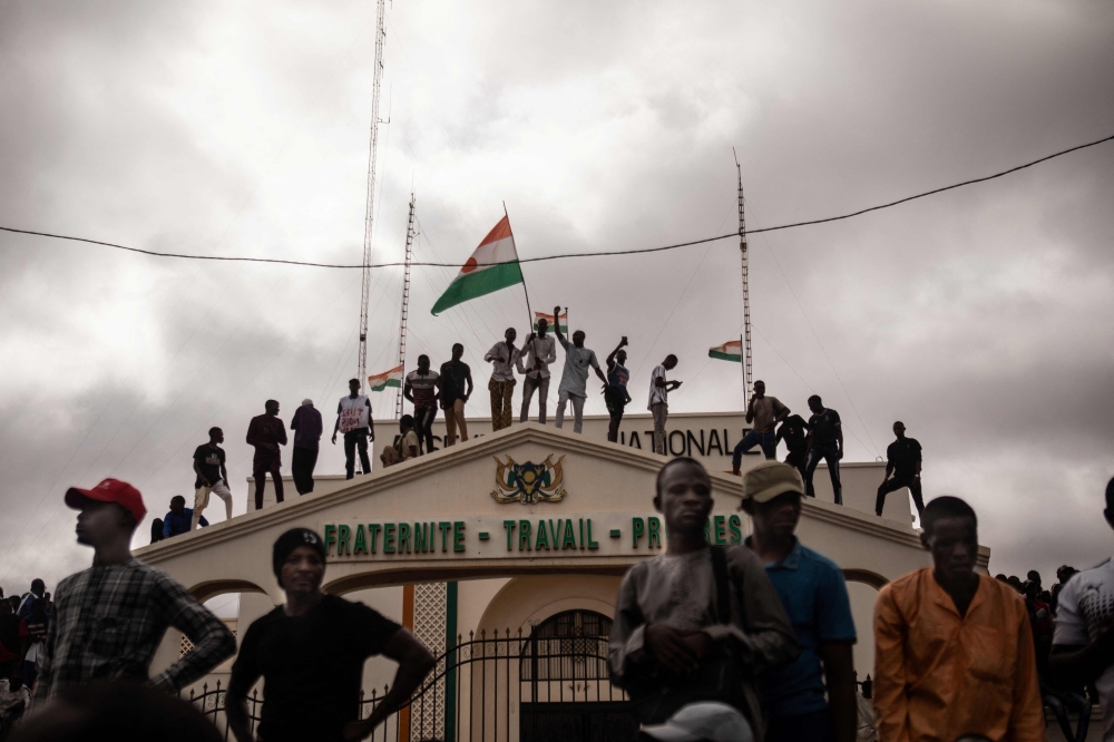 File: Protesters hold a Niger flag during a demonstration on independence day in Niamey on August 3, 2023. The demonstrators converged at Concertation Square in the heart of the city, following a call by a coalition of civil society associations on a day marking the country's 1960 independence from France. (Photo by AFP)