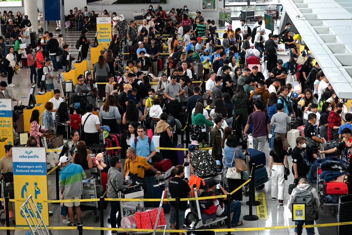 People queue at the check-in counters at Ninoy Aquino International Airport in Pasay, Metro Manila on December 22, 2023. Photo by JAM STA ROSA / AFP