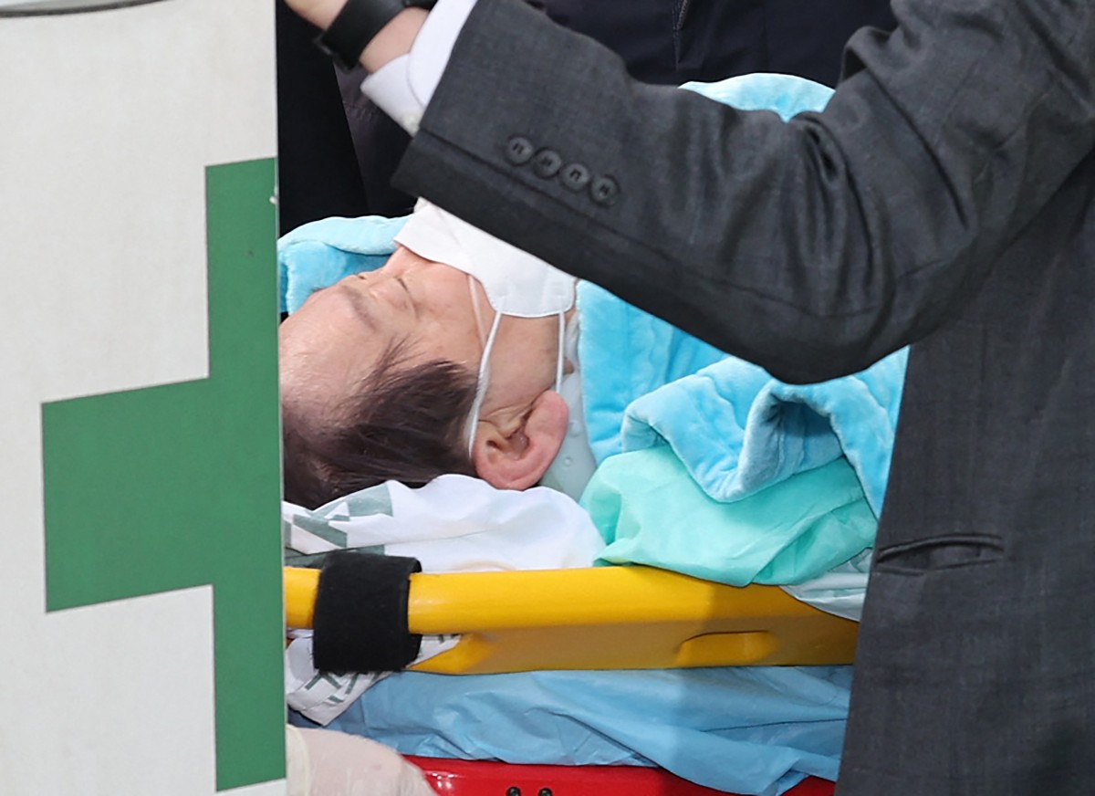 South Korean opposition party leader Lee Jae-myung, who was attacked in Busan, lies on a stretcher as he arrives at Seoul National University Hospital in Seoul on January 2, 2024. Photo by Yonhap / YONHAP / AFP