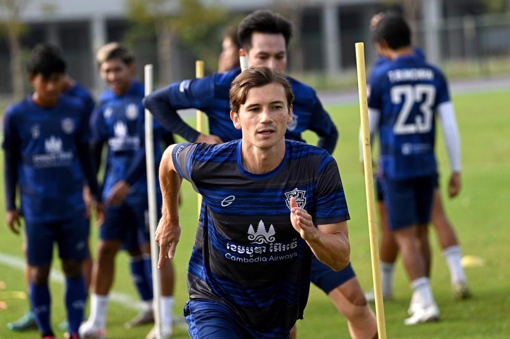 This photo taken on January 3, 2024 shows French footballer Antoine Lemarie (C) warming up during a training session with the Cambodian premier league's Boeung Ket FC team. (Photo by Tang Chhin Sothy / AFP)