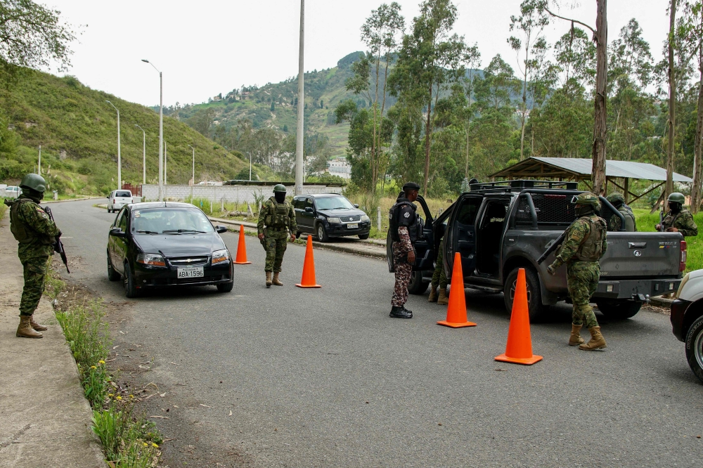 Soldiers check cars during a security operation on the alternative road to the Turi prison, in Cuenca, Ecuador, on January 9, 2024, a day after Ecuadorean President Daniel Noboa declared a state of emergency following the escape from prison of a dangerous narco boss. (Photo by Fernando Machado / AFP)
