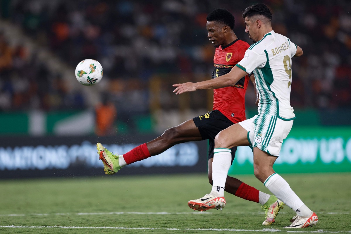 Angola's defender #5 Kinito fights for the ball runs with the ball Algeria's forward #9 Baghdad Bounedjah during the Africa Cup of Nations (CAN) 2024 group D football match between Algeria and Angola at Stade de la Paix in Bouake on January 15, 2024. (Photo by KENZO TRIBOUILLARD / AFP)