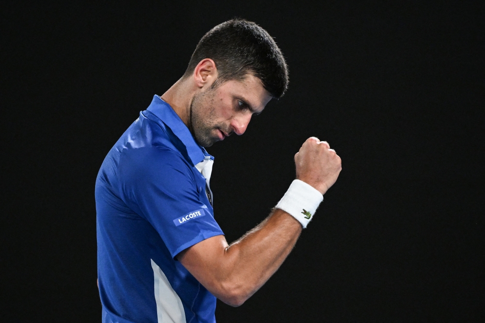Serbia's Novak Djokovic reacts after a point against Argentina's Tomas Etcheverry during their men's singles match on day six of the Australian Open tennis tournament in Melbourne on January 19, 2024. (Photo by WILLIAM WEST / AFP) 