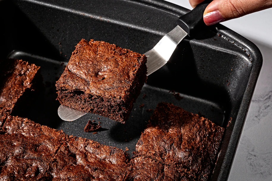 A metal pan and an offset spatula are brownie tools of engagement. (Scott Suchman for The Washington Post/food styling by Lisa Cherkasky for The Washington Post)
