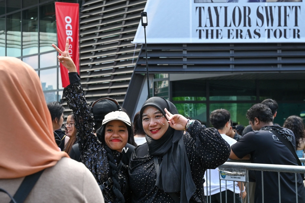 Fans of US singer Taylor Swift, also known as Swifties, take photos as they arrive for the pop star's Eras Tour concert at the National Stadium in Singapore on March 7, 2024. (Photo by Roslan Rahman / AFP)