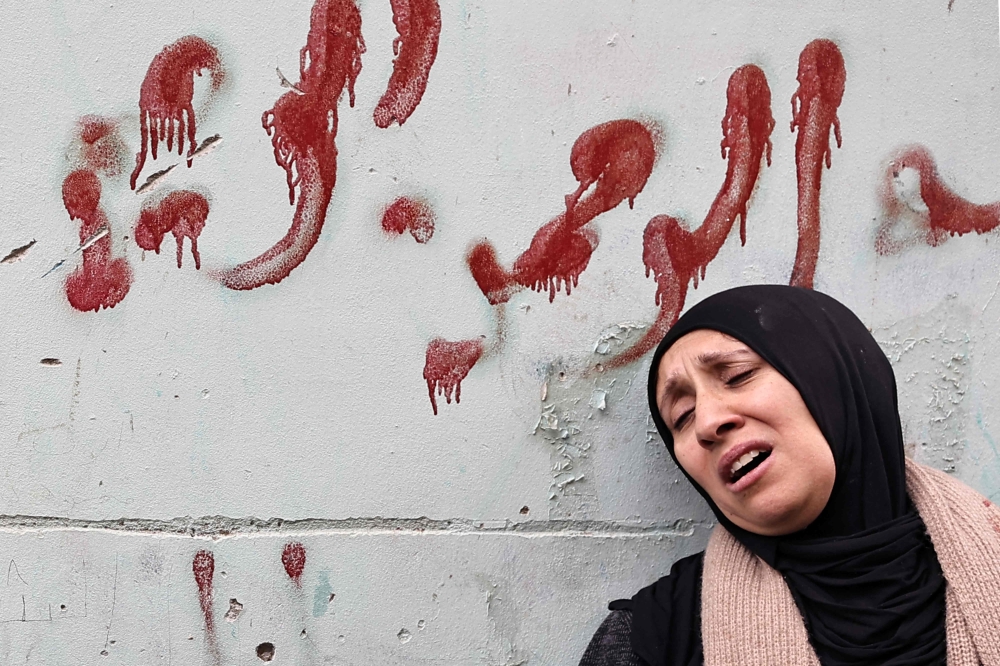 File: The mother of Muhammad Ayman Ghazawi and Basel Ayman Ghazawi, two of three Palestinian men killed by undercover Israeli agents mourns during their funeral in the occupied West Bank city on January 30, 2024. (Photo by Zain Jaafar / AFP)