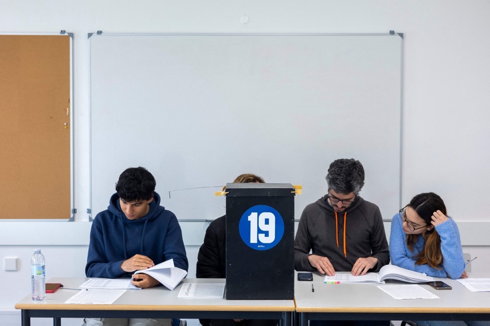 Polling supervisors check lists at a polling station in Parque das Nacoes, Lisbon, during the legislative elections held on March 10, 2024 in Portugal. (Photo by ANDRE DIAS NOBRE / AFP)
