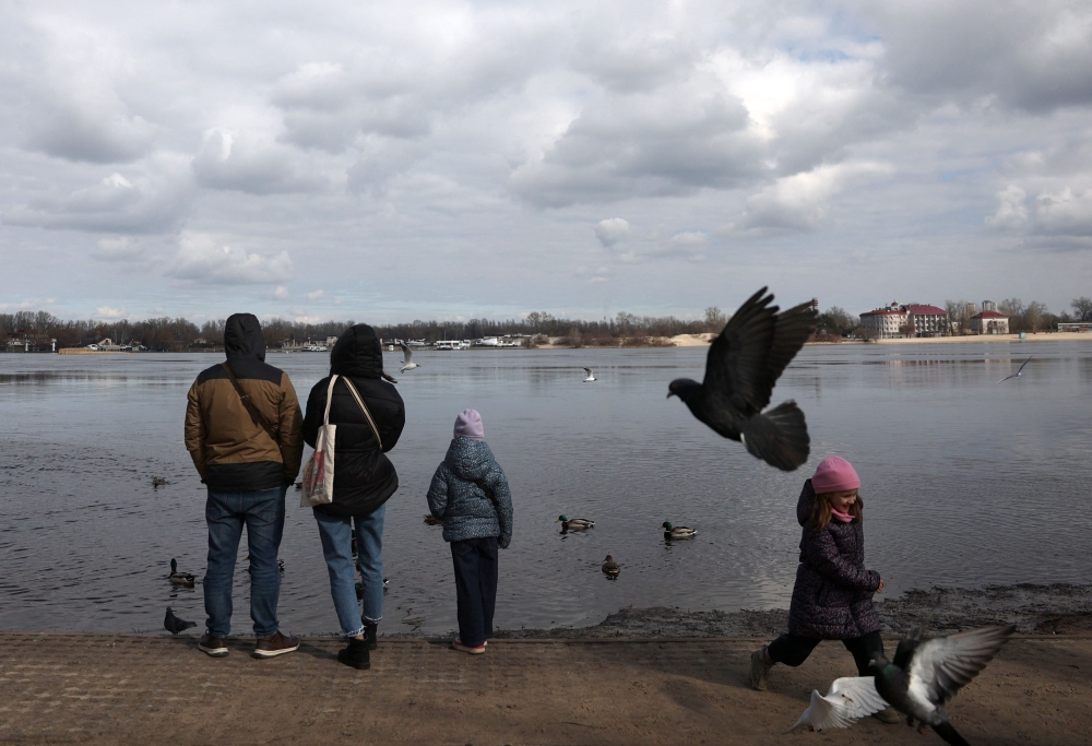 Local residents feed birds in a park on the banks of the Dnipro River in Kyiv on March 9, 2024, amid the Russian invasion of Ukraine. (Photo by Anatolii STEPANOV / AFP)
