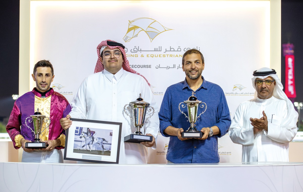 The connections of Safi Al Zaman pose for a photo after receiving their trophies from QREC Racing Manager Rashid Al Kubaisi (right).   
