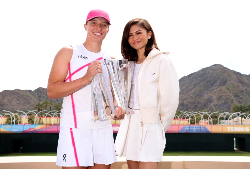Iga Swiatek of Poland poses for a photograph with Hollywood actress Zendaya and the winners trophy after her straight sets victory against Maria Sakkari of Greece in the Women's Final during the BNP Paribas Open at Indian Wells Tennis Garden on March 17, 2024 in Indian Wells, California. (Photo by CLIVE BRUNSKILL / GETTY IMAGES NORTH AMERICA / Getty Images via AFP)
