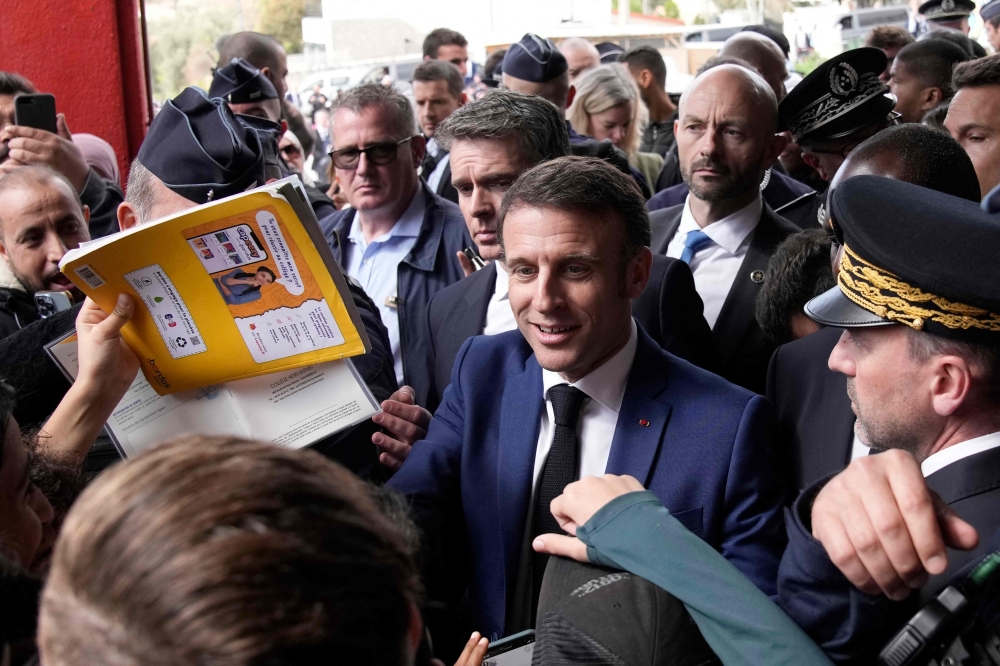 French President Emmanuel Macron meets with residents during a visit focusing on security and the fight against drug trafficking, in La Castellane district of Marseille, southeastern France, on March 19, 2024. Photo Credit: Christophe Ena / POOL / AFP.