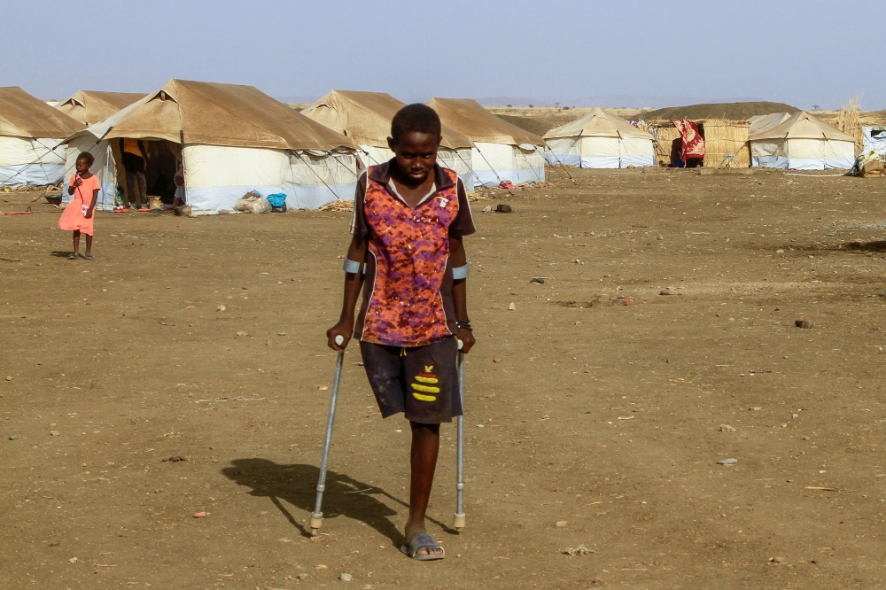 A picture taken on March 20, 2024, shows children who fled Khartoum and Jazira states in war-torn Sudan standing near tents at a camp for the internally displaced in southern Gadaref state. (Photo by AFP)