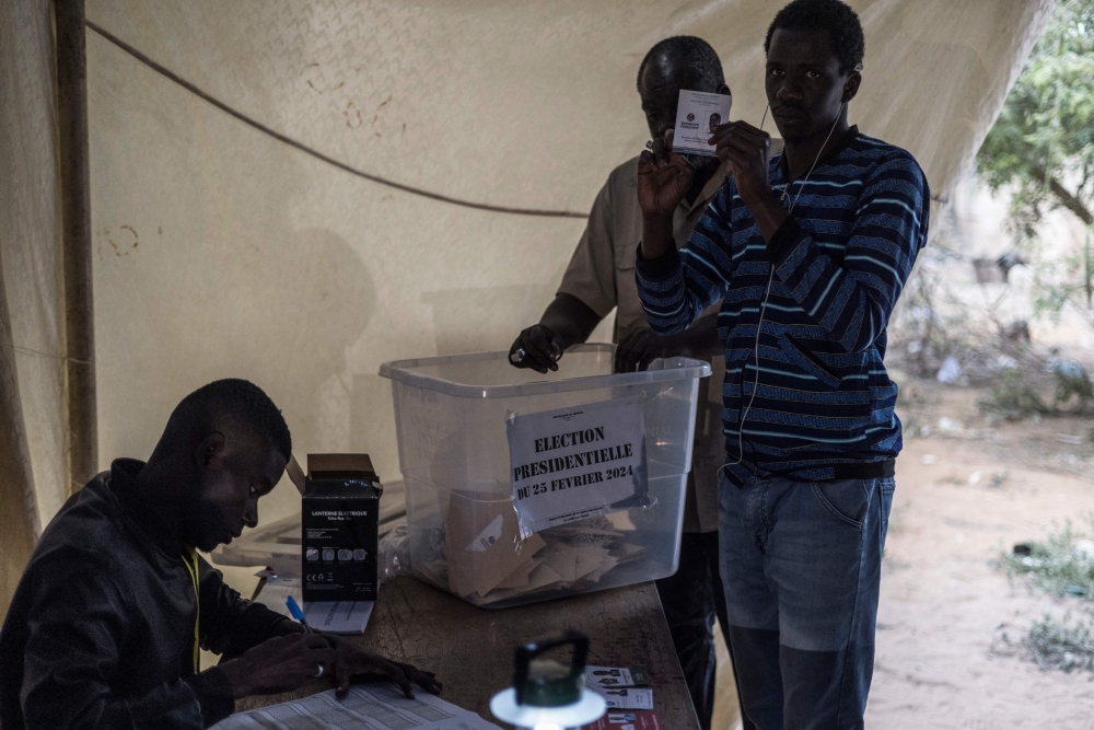 A polling station official shows a ballot to party assessors ballots at the start of the counting proceedings in Dakar, on March 24, 2024. (Photo by MARCO LONGARI / AFP)
