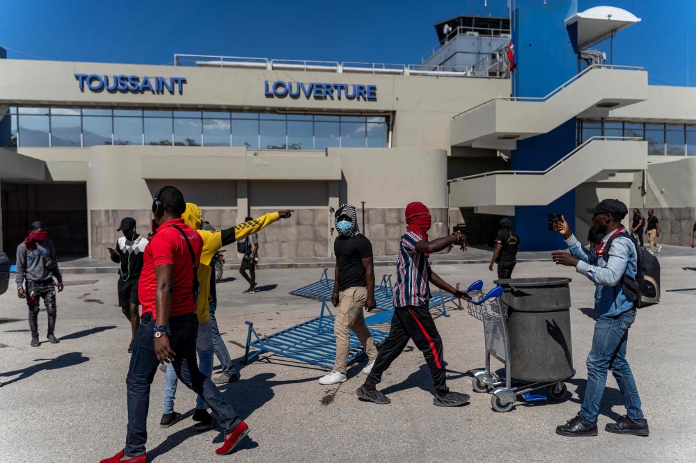 (FILES) Demonstrators break into the Toussaint Louverture International Airport to protest the recent killings of six police officers by armed gangs, in Port-au-Prince, Haiti, January 26, 2023. (Photo by Richard Pierrin / AFP)
