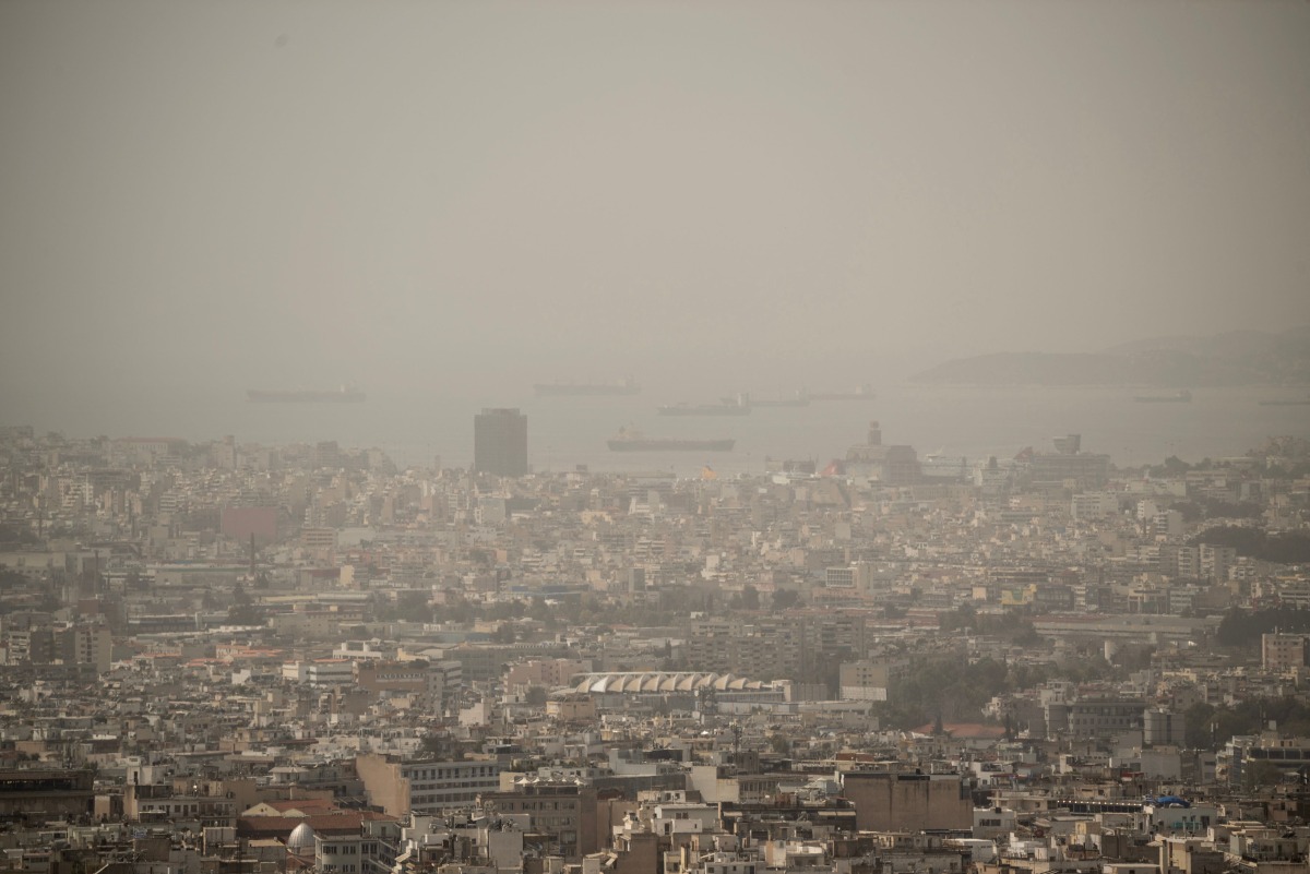 This photo taken on March 27, 2024 shows the city of Athens shrouded in haze as persistent southerly winds have carried waves of dust from the African continent across the eastern Mediterranean. (Photo by Angelos TZORTZINIS / AFP)

