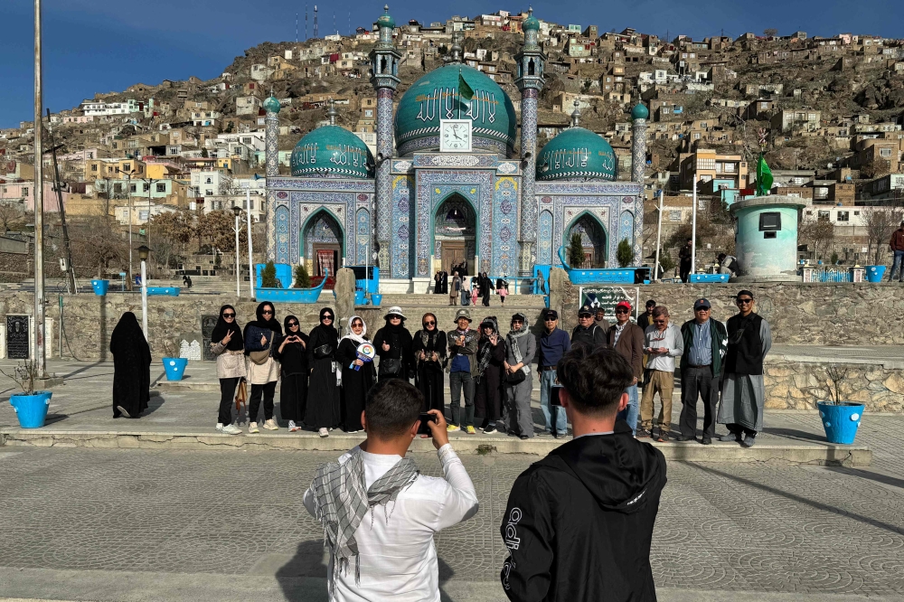 In this picture taken on March 25, 2024 Thai tourists pose for a group picture during their visit to the Kart-e-Sakhi Shrine in Kabul. (Photo by Wakil Kohsar / AFP) 