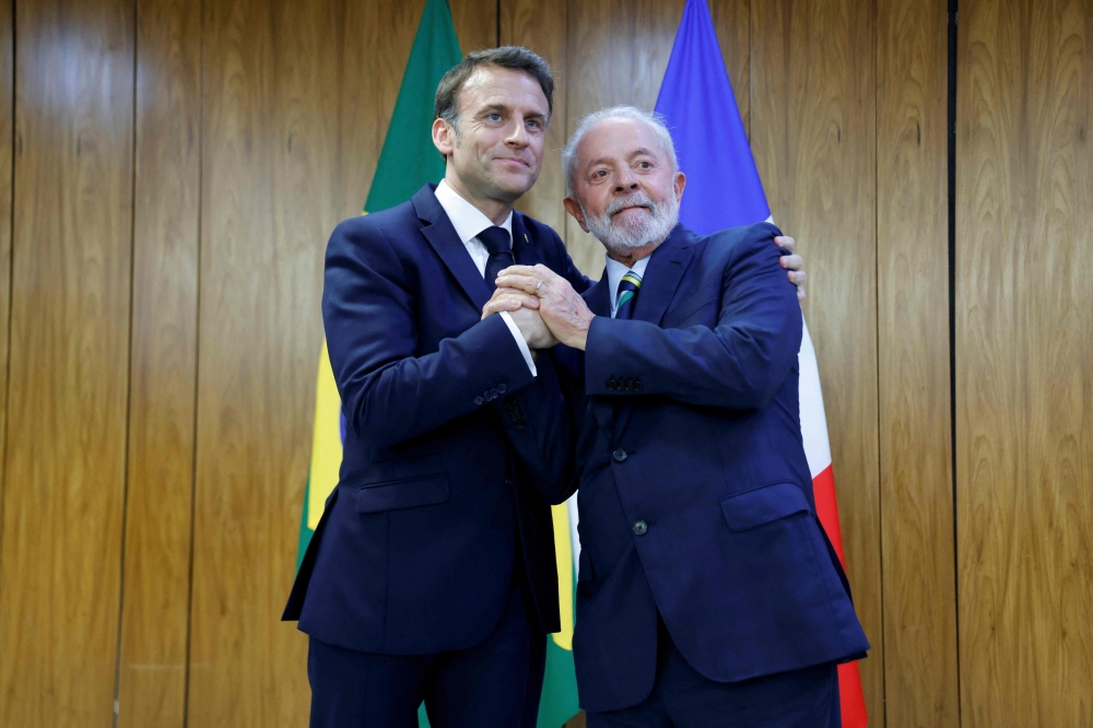 Brazil's President Luiz Inacio Lula da Silva (right) and France's President Emmanuel Macron pose for a picture during a bilateral agreement signing ceremony at the Planalto Palace in Brasilia on March 28, 2024. (Photo by Ludovic Marin / POOL / AFP)