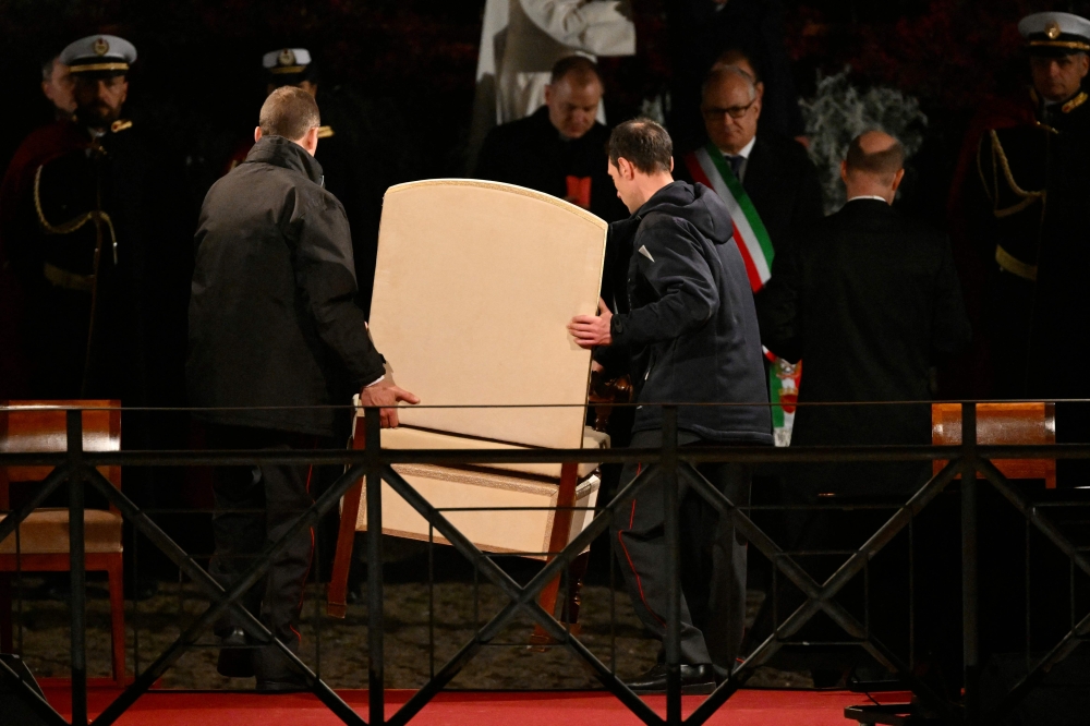 The armchair of Pope Francis is removed after the Vatican announced the Pope will not come to the Colosseum to preside the Way of the Cross (Via Crucis) as part of the Holy Week celebrations, on March 29, 2024 in Rome. (Photo by Alberto PIZZOLI / AFP)
