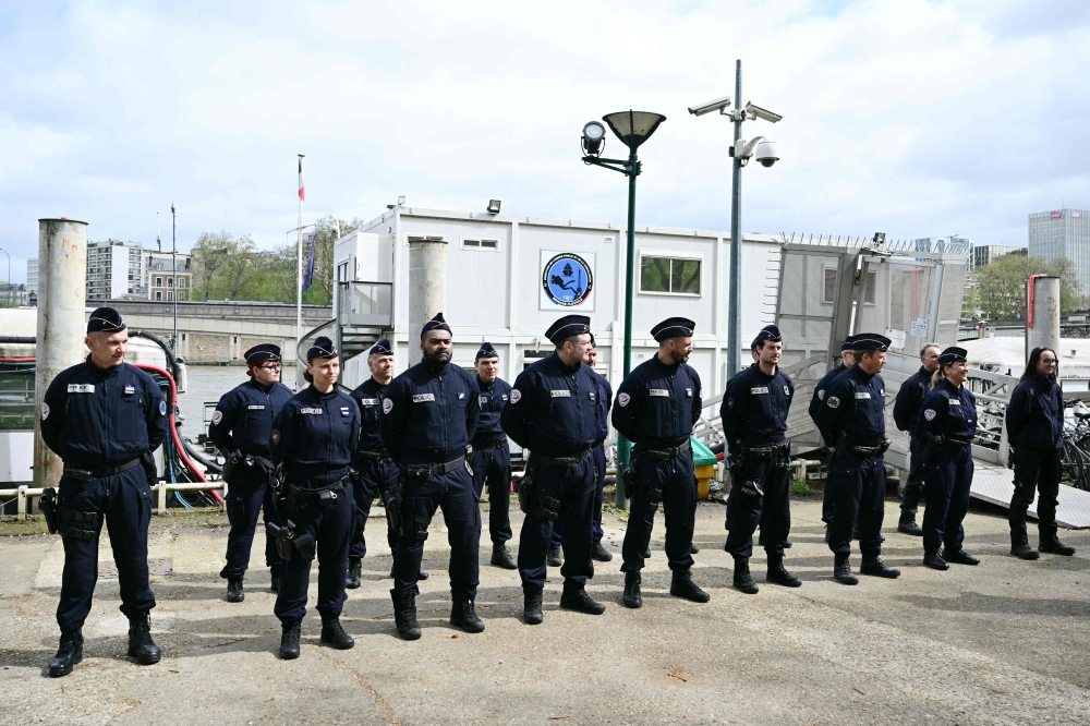 Members of the French police's River Brigade (Brigade Fluviale) wait to meet Minister for Interior and Overseas during a visit dedicated to the security measures ahead of the opening ceremony of the Olympics in Paris on April 9, 2024. Photo by MIGUEL MEDINA / AFP.