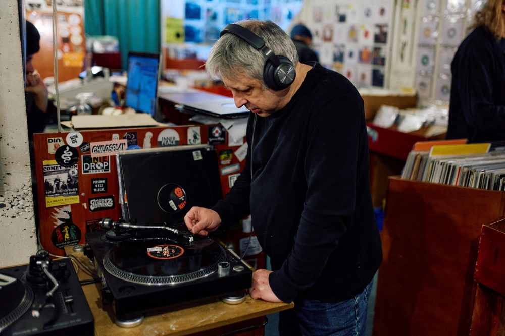 A customer listens to a vinyl at indie record store Flashback Records in London on April 18, 2024. (Photo by BENJAMIN CREMEL / AFP)