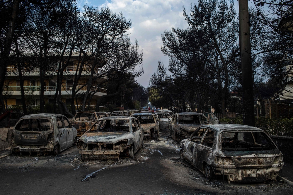 This photo taken on July 24, 2018 show cars burnt following a wildfire at the village of Mati, near Athens, on July 24, 2018. Photo by ANGELOS TZORTZINIS / AFP