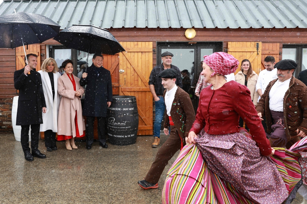 French President Emmanuel Macron (L) and his wife Brigitte Macron (2ndL), Chinese President Xi Jinping (4thL) and his wife Peng Liyuan (3rdL) watch folklore dancers at the Tourmalet pass, in the Pyrenees moutains, as part of his two-day state visit to France, on May 7, 2024. (Photo by Aurelien Morissard / POOL / AFP)
