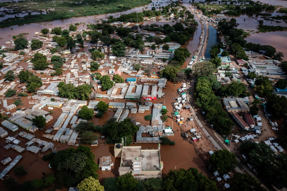 This aerial view shows the damages of a main road and houses submerged in water following heavy floods in Garissa, on May 8, 2024. (Photo by LUIS TATO / AFP)
