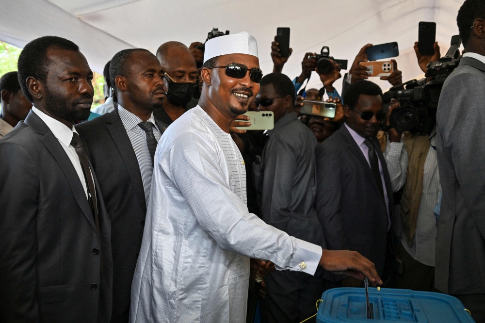(FILES) Chad's transitional president and presidential election candidate Mahamat Idriss Deby Itno (C) casts his ballot at a polling station in N'Djamena on May 6, 2024 during Chad's presidential election. (Photo by Issouf SANOGO / AFP)

