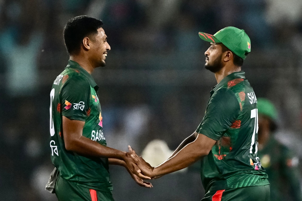 Bangladesh's Mustafizur Rahman (L) celebrates with Shakib Al Hasan after taking the wicket of Zimbabwe's Luke Jongwe (not pictured) during the fourth Twenty20 international cricket match between Bangladesh and Zimbabwe at the at Sher-e-Bangla National Cricket Stadium in Dhaka on May 10, 2024. (Photo by MUNIR UZ ZAMAN / AFP)
